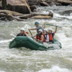 people rafting on green raft